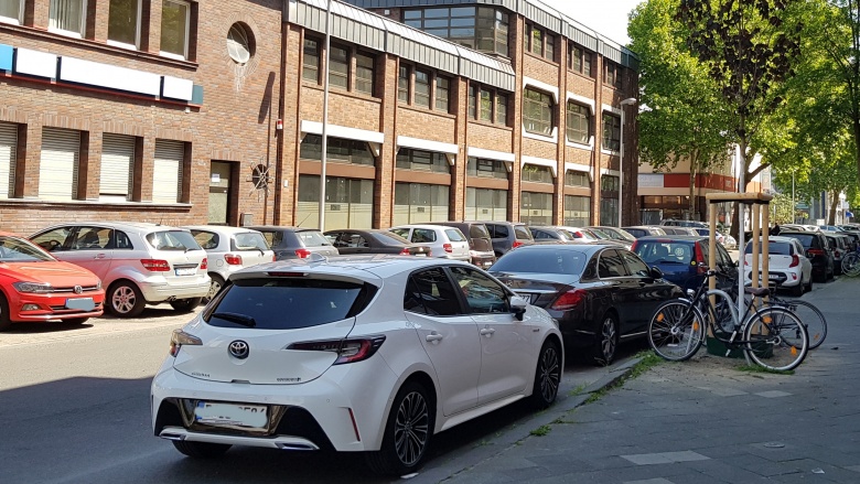 Foto einer Straße mit vielen parkenden Autos